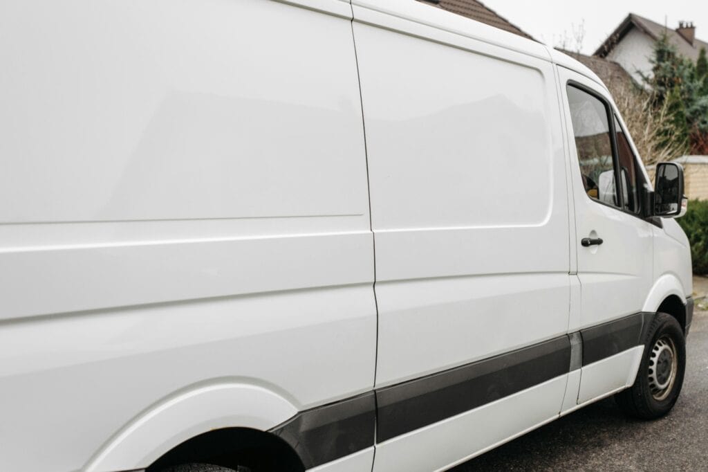 A white moving van in front of a house