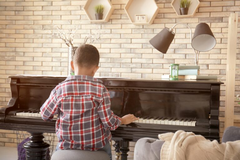 A boy playing the piano in the living room in the concept of 'How to Move Pianos and Other Large Fragile Objects When Moving House to Richmond'.